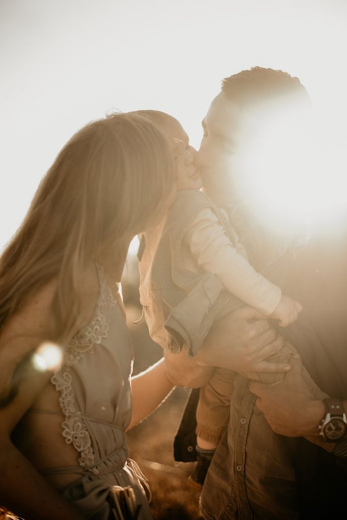 Parents kissing there child at The Nut Farm Venue by Echo Photography